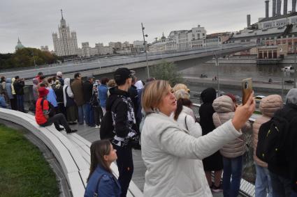 Москва. Прохожие на набережной фотографируют парад теплоходов в честь Дня города на Москве-реке.