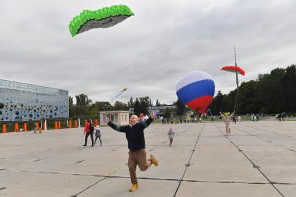 Москва.   Празднование Дня города Москвы на ВДНХ. Мужчина запускает воздушного змея.