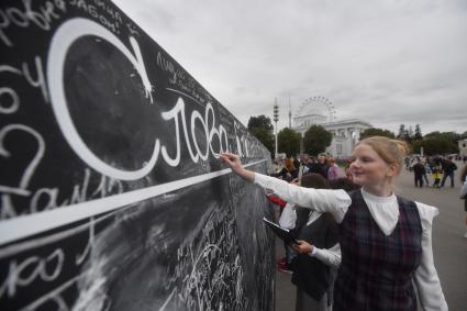 Москва. Празднование Дня города Москвы на ВДНХ. Девочка у доски `Слов благодарности учителям`.