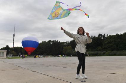 Москва.   Празднование Дня города Москвы на ВДНХ. Девушка запускает воздушного змея.