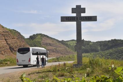 Сахалинская область. Автобус стоит у придорожного креста.