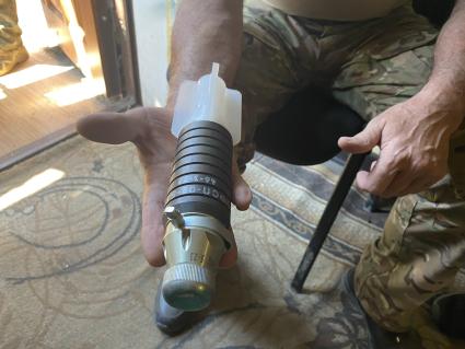 Донецкая область. г.Бахмут (Артемовск). Разведчик показывает мину для сброса с дрона.
