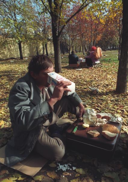 Москва. 1993г. Октябрьский путч. Мужчина пьет молоко из пакета в сквере.