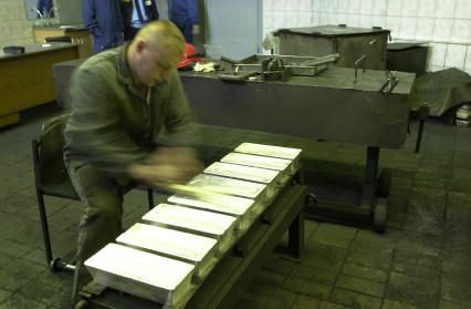 Новосибирск. Сотрудник обрабатывает золотые слитки на Новосибирском аффинажном заводе.