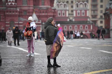 Москва.  Прохожие  на Красной площади во время дождя.