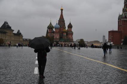 Москва.  Прохожие  на Красной площади во время дождя.