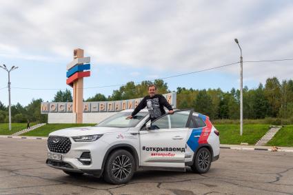 Амурская область. Фотокорреспондент `Комсомольской правды` Михаил Фролов у стеллы Москва-Владивосток во время автопробега `Открываем Дальний`.