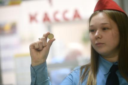 Екатеринбург. Дежурная по станции держит жетон московского метрополитена, используемые для прохода через турникет. и проезда в Екатеринбургском метро. Екатеринбургский метрополитен принял решение к концу 2024 года отказаться от использования металлических жетонов