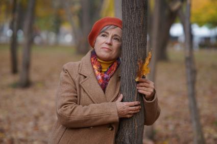 Самара. Женщина стоит у дерева в парке.