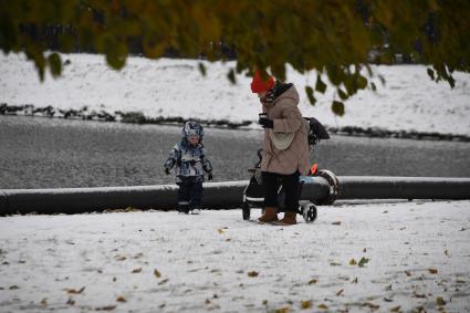 Москва. Женщина с ребенком гуляют в парке у пруда.
