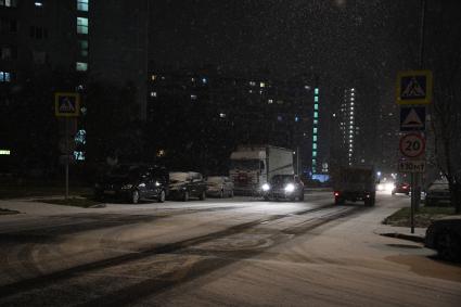 Москва. Машины движутся по вечерней улице во время снегопада.