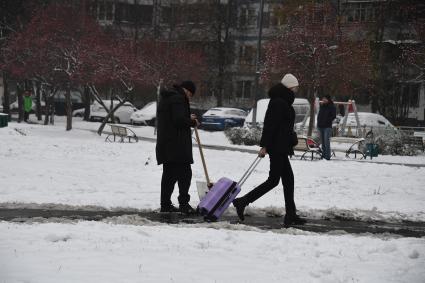 Москва.  Девушка с чемоданом  на заснеженной улице.