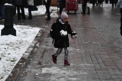 Москва.  Девочка держит в руках снежок.