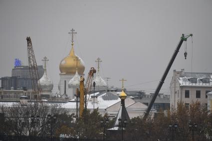 Москва. Церковные купола и строительные краны.
