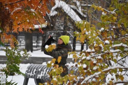 Москва.  Девушка фотографирует в парке `Музеон`.