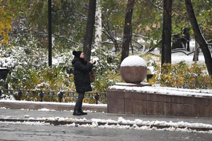 Москва. Женщина фотографирует на улице.