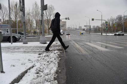 Москва. Мужчина переходит дорогу по пешеходному переходу.