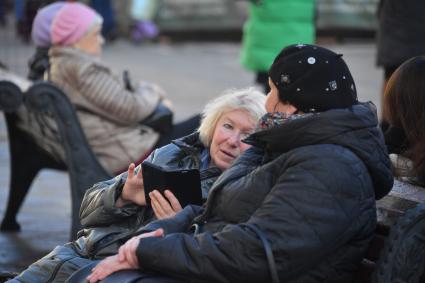 Москва. Женщины пенсионного возраста  сидят на скамейке на улице.