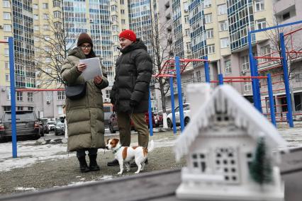 Екатеринбург. Молодая пара с документами на квартиру, во дворе многоквартирного жилого дома