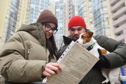 Екатеринбург. Молодая пара с документами на квартиру, во дворе многоквартирного жилого дома