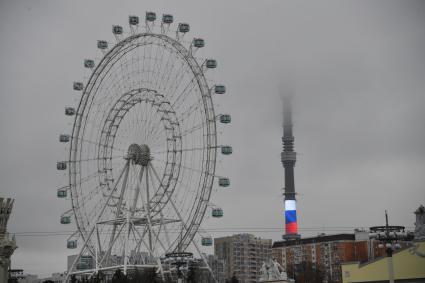 Москва.   Колесо обозрения `Солнце Москвы` и Останкинская башня в тумане.