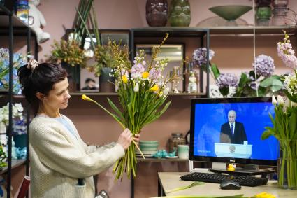 Девушка смотрит трансляцию послания президента РФ В. Путина к Федеральному Собранию