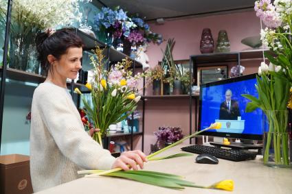 Девушка смотрит трансляцию послания президента РФ В. Путина к Федеральному Собранию