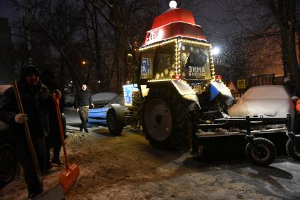 Трактор с новогодним дзайном убирает снег