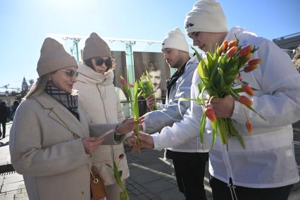 Волонтеры раздают цветы женщинам 8 марта