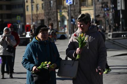 Волонтеры раздают цветы женщинам 8 марта