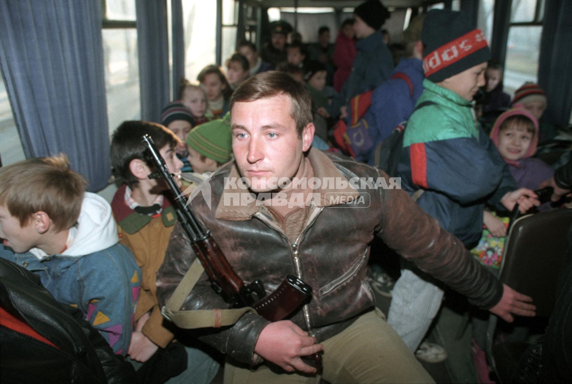 дети в автобусе с военным