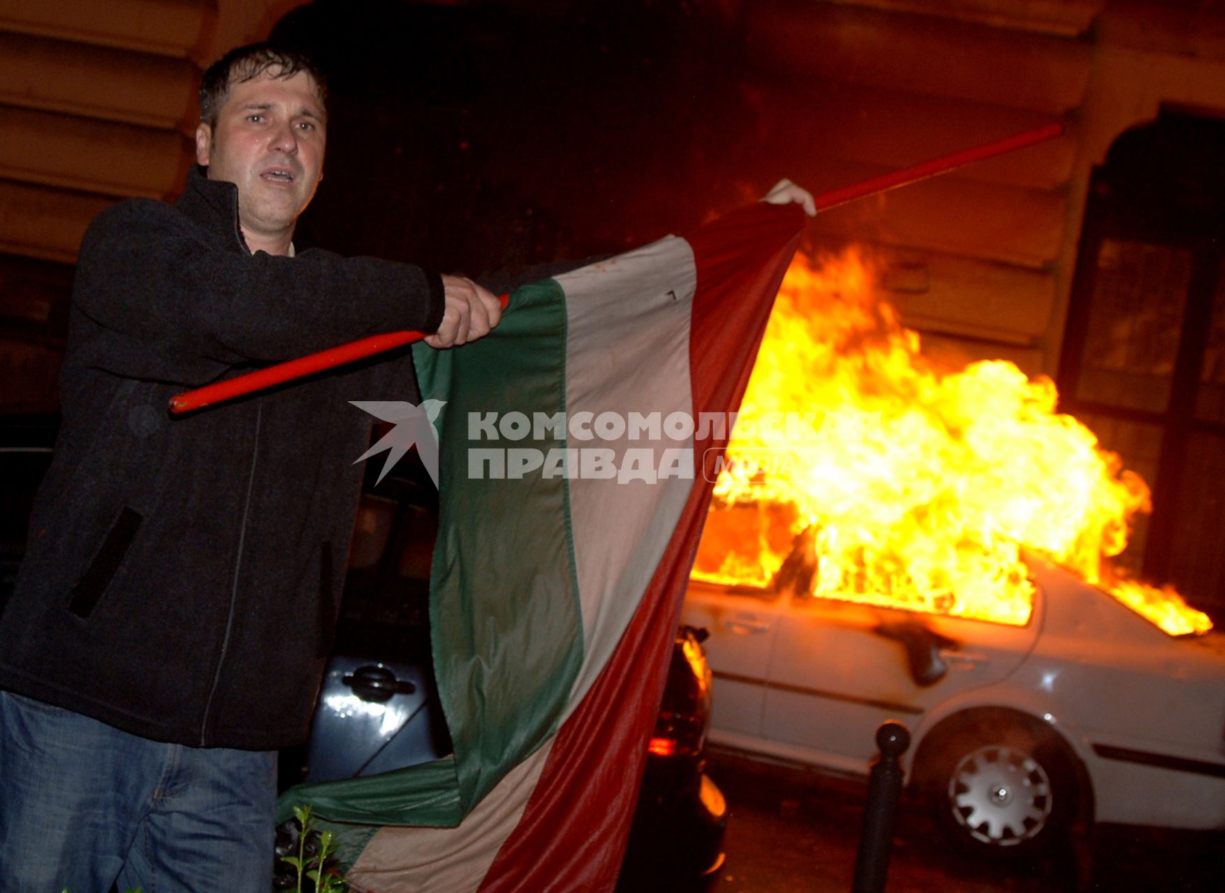 Беспорядки в Венгрии
A Hungarian right-wing protester waves a national flag in front of a burning TV car as demonstrators storm the headquarters of the Hungarian State Television during an escalating protest against Hungary\\\'s socialist government in Budapest, Hungary, early Tuesday, Sept. 19, 2006. The protest started on Sunday evening calling for Prime Minister Ferenc Gyurcsany to resign. Gyurcsany has admitted saying that his party lied to the public to win April\\\'s general election. Gyurcsany\\\'s admission came after Hungarian radio played a tape of a meeting he had with his Socialist MPs a few weeks after the election. Hungarian President Laszlo Solyom declared Monday, that the country is in moral crisis. (AP Photo/Bela Szandelszky)