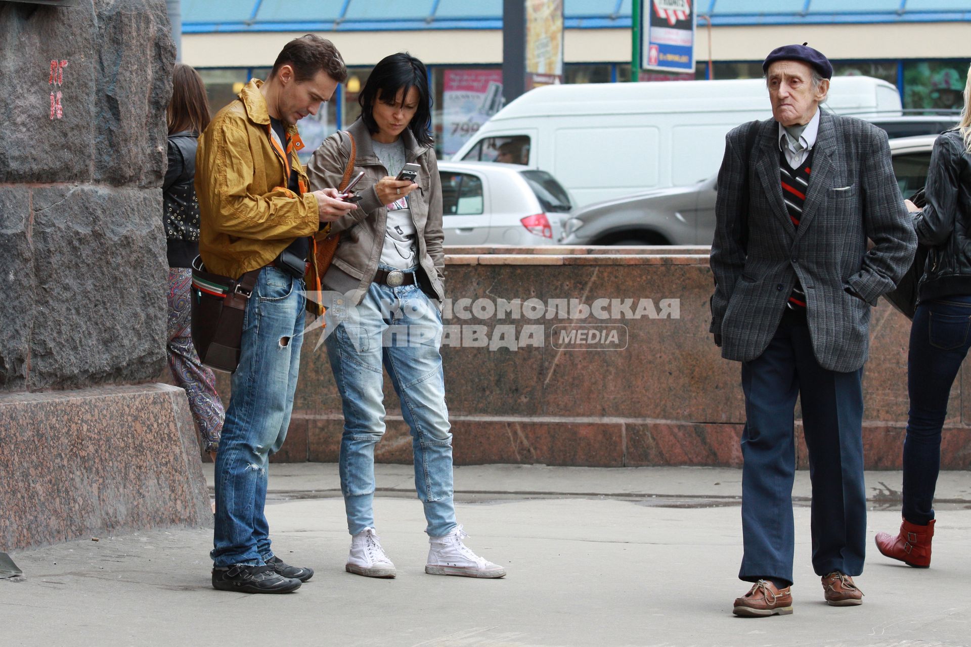 Жанровое фото с Тверской улицы, Москва, 17 июня 2010 года. Старые. Молодые. Старики. Молодежь. Сотовый телефон. Мобильная связь.