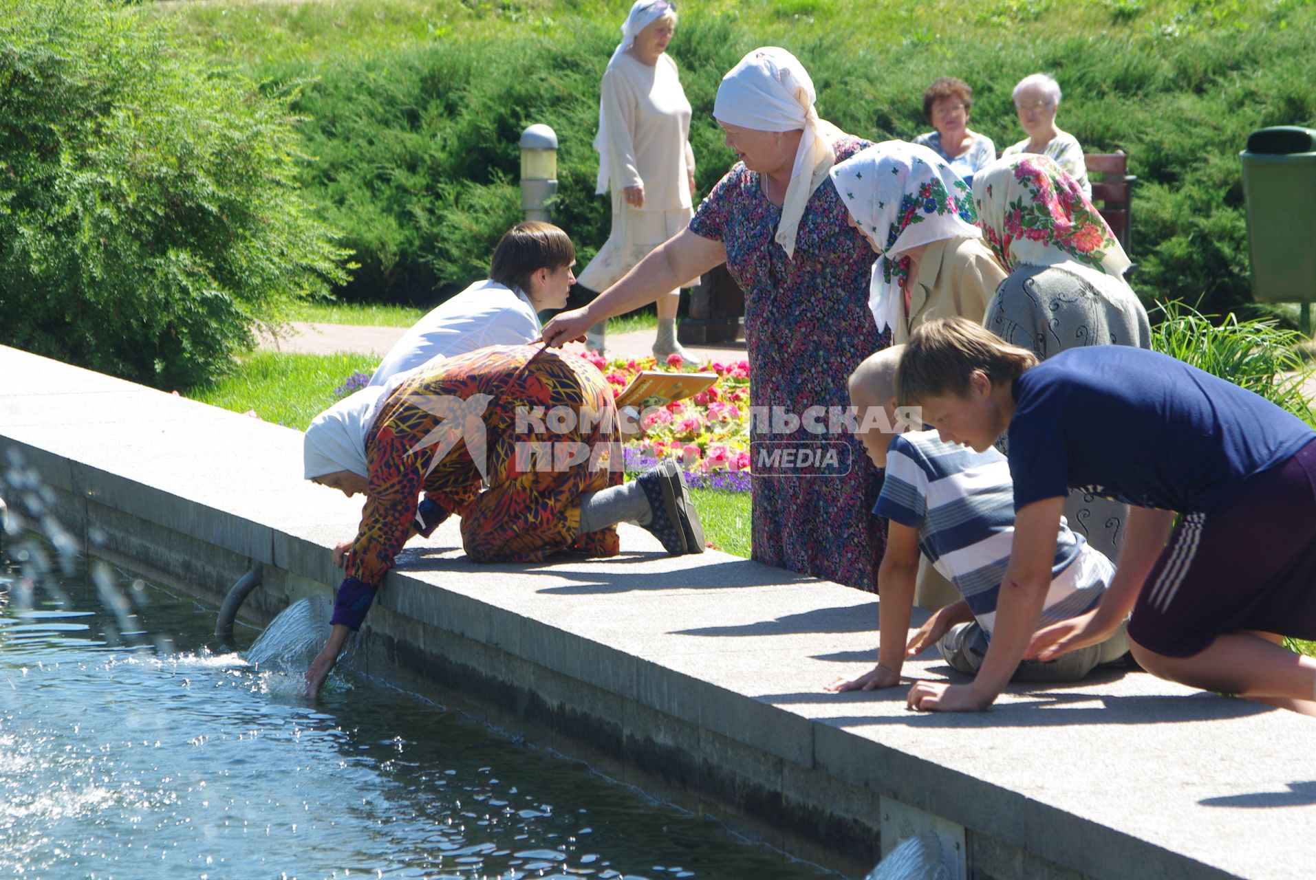 Жаркая погода в Москве, чтобы освежиться старушка пьет воду из фонтана. 27 июня 2010 года. В течение нескольких дней столбик термометра поднимается выше 30 градусов. Погода. Глобальное потепление. Лето. Зной. Фонтаны. Отдых. Старость. Пенсия. Старики. Дети.