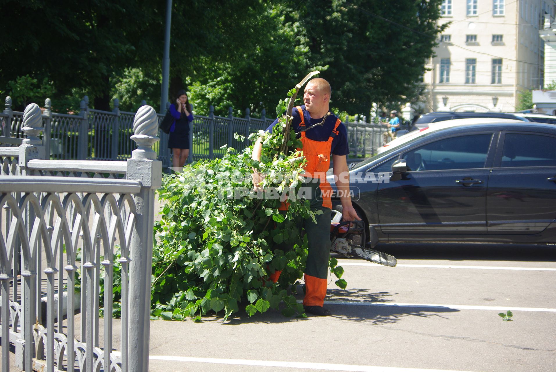 Обрезка деревьев от ненужных веток, 30 июня 2010 года. Гастарбайтер. Рабочий. Благоустройство города. Ветки. Деревья.  Коммунальные службы. Бензопила. Лето. Жара.