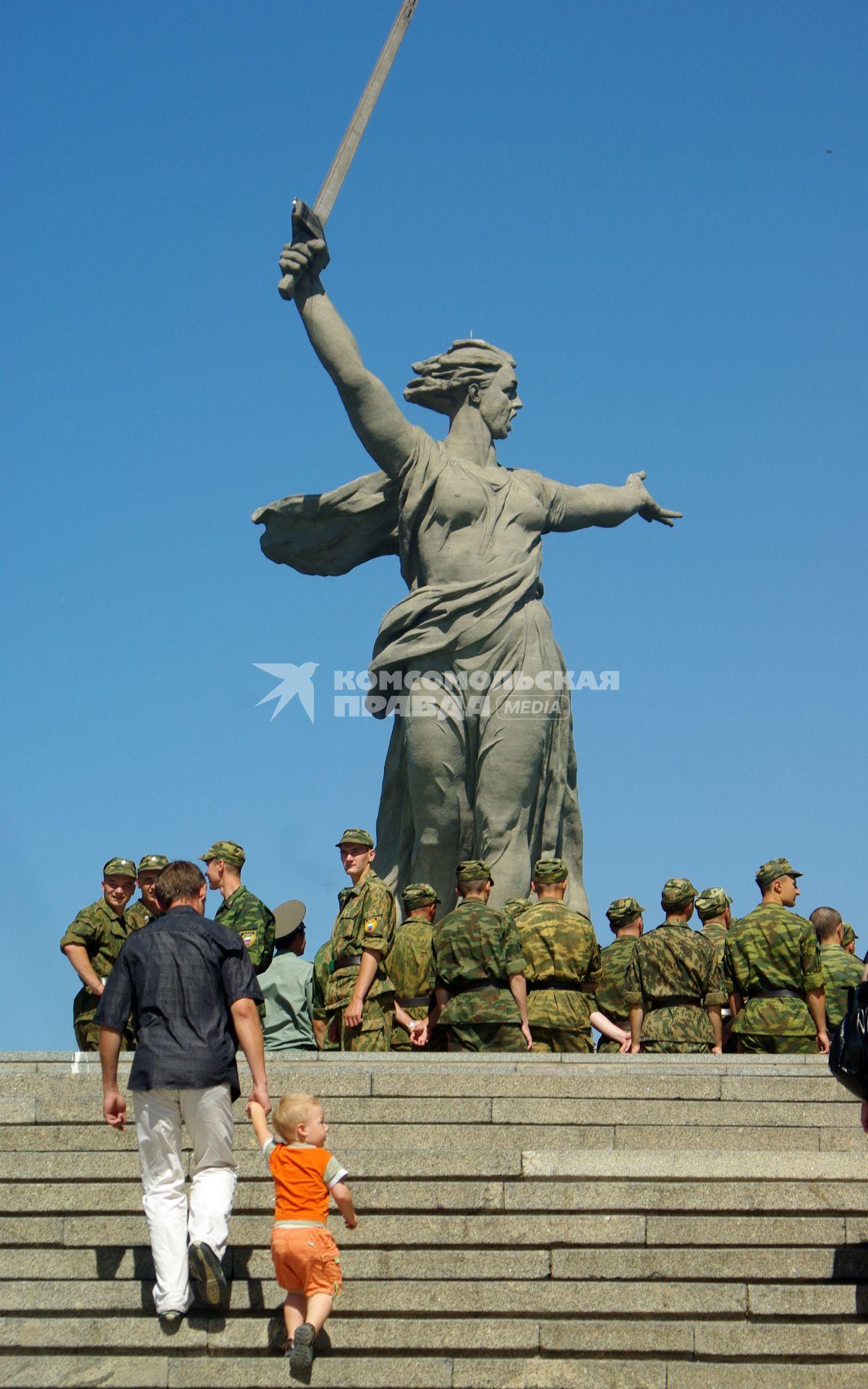 По ступеням Мамаева Кургана поднимаются солдаты и отец с маленьким сыном, 20 июня 2010 года. Мемориал. Волгоград. Праздник. День Победы. Родина Мать. Солдаты. Дети. Отец и сын. Детство.