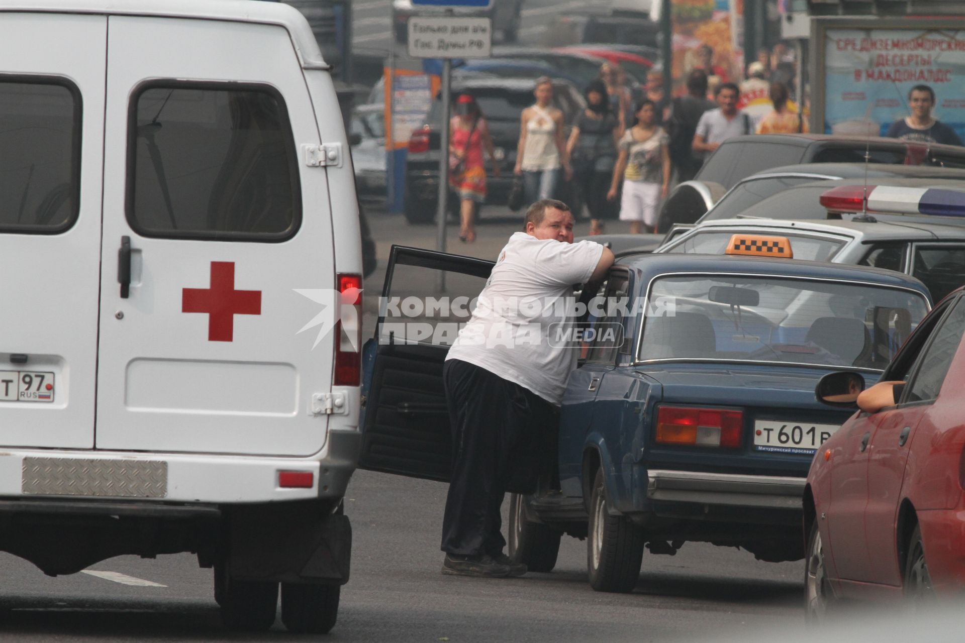 Жара и смог от лесных пожаров , Манежная площадь, Москва,  9 августа 2010 года. Климат. Лето. Автомобили. Лишний вес. Здоровье. Толстяк. Скорая помощь. Медицина. Такси. Таксист. Пассажир. Транспорт городской.