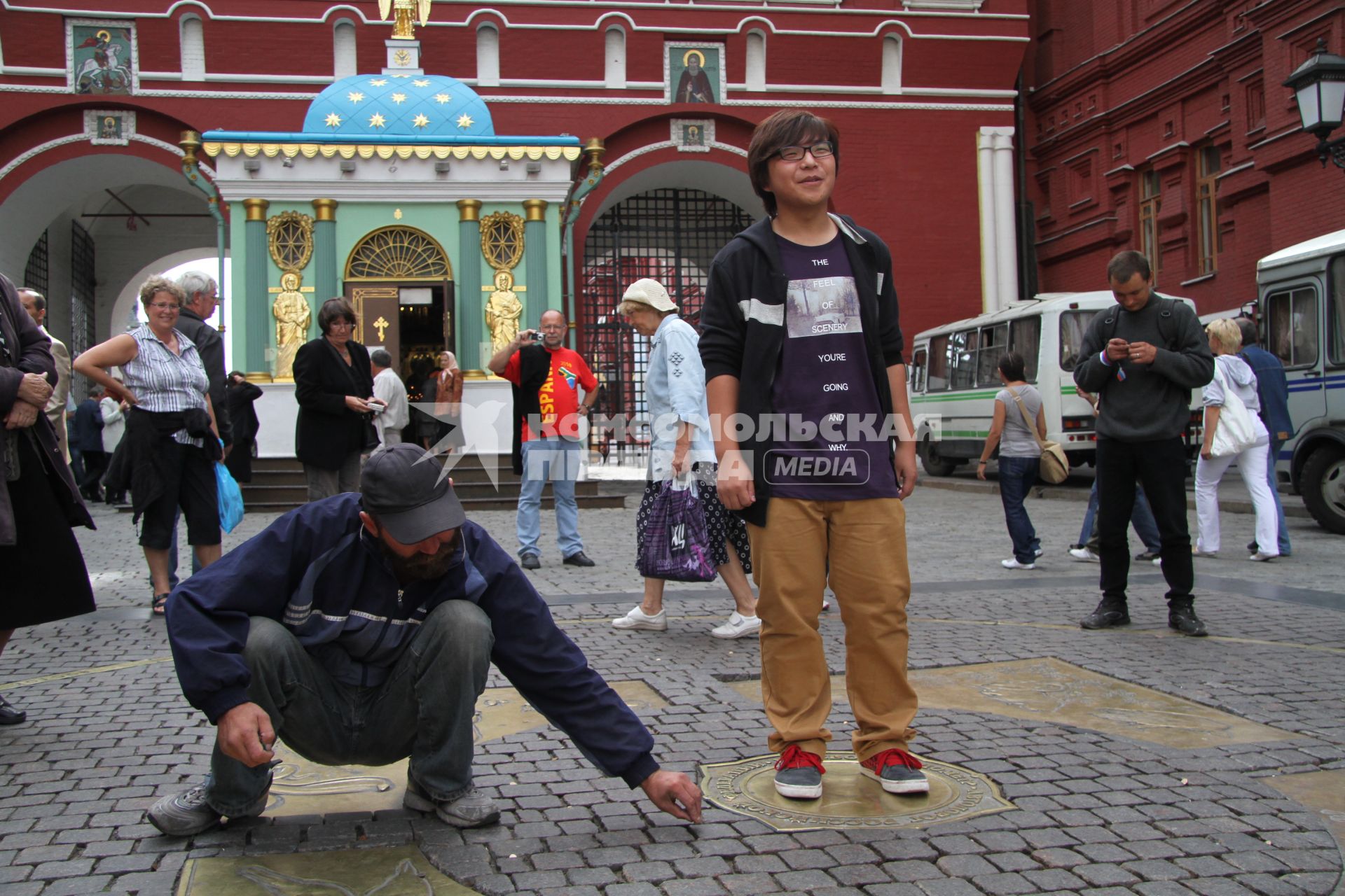 Туристы фотографируются на Красной площади, на отметке НУЛЕВОЙ КИЛОМЕТР, Москва,  23 августа 2010 года.  Бомжи. Заработок. Мелочь. Деньги. Сбор.