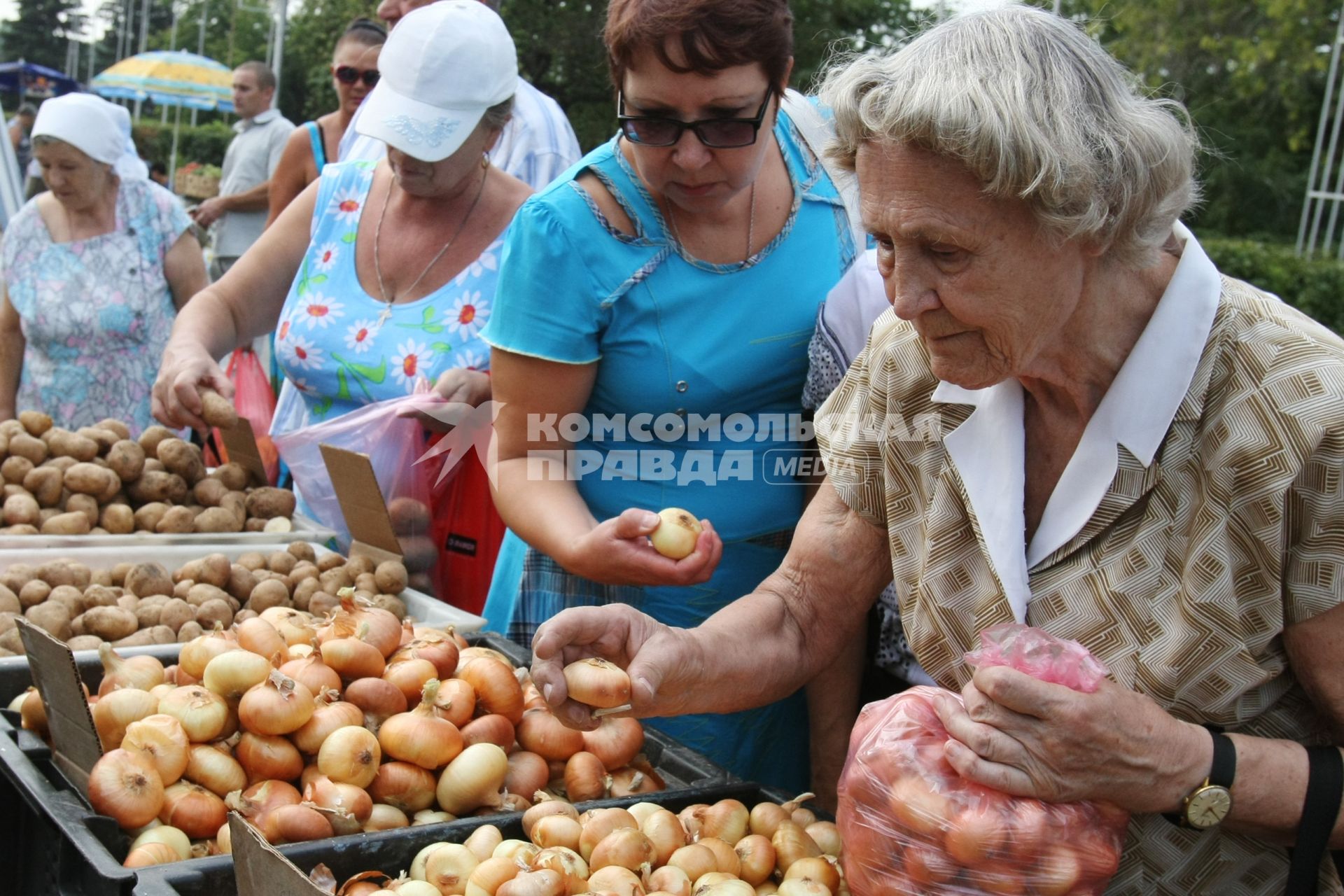 13.08.2010 Самара, Россия. Женщины покупают лук на рынке.