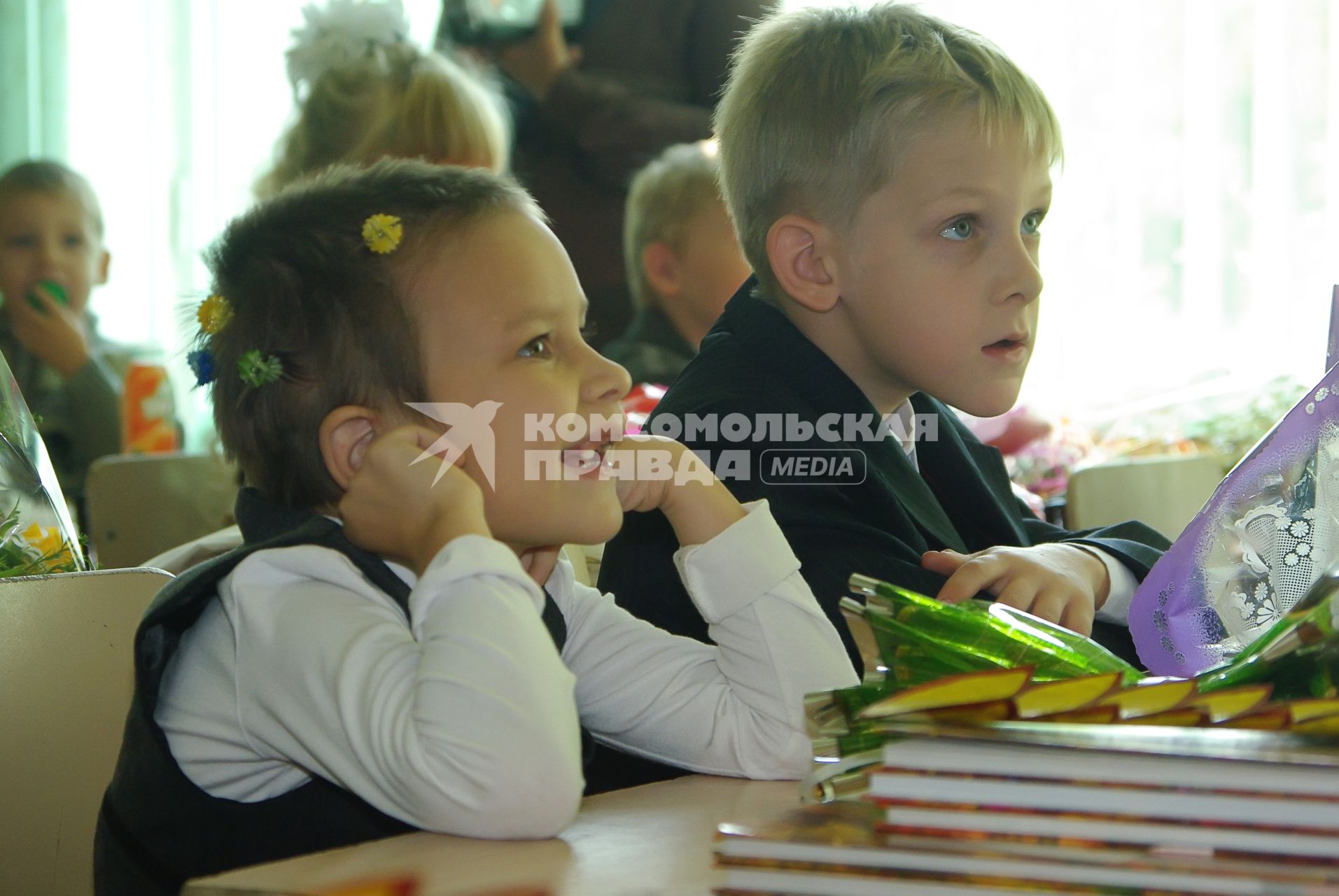 Беззубая девочка и мальчик- первоклассники за партой в школе, 1 сентября 2010 года. Школа, учебнки, зубной врач, зубы, первоклассник, урок, парта, знания, учеба, дети.
