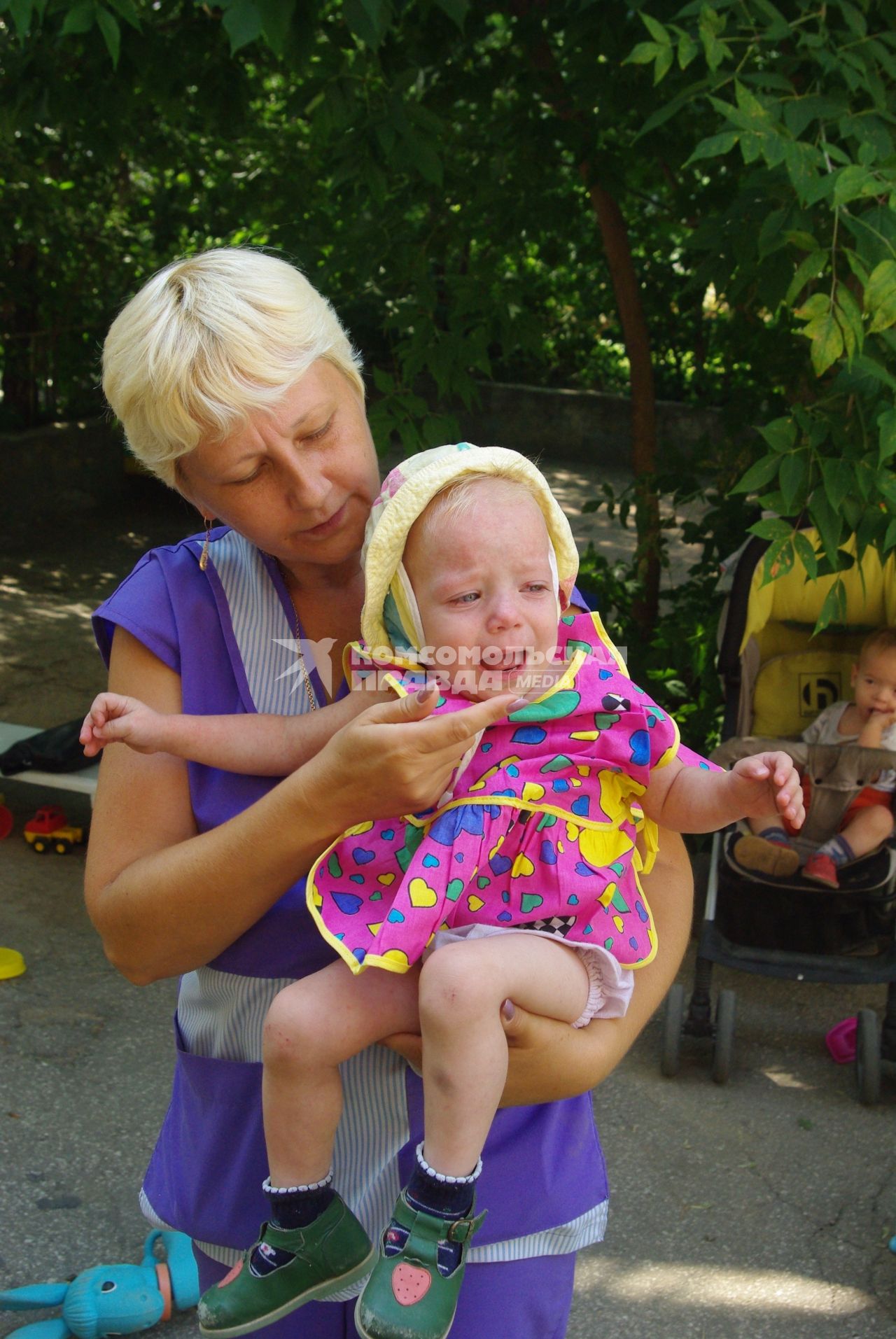 Сирота на руках воспитателя в детском доме, 2 августа 2010 года. Дети, детский дом, детдом, ребенок, манеж, игрушки, сиротка, воспитатель, учитель, мама, семтя, ребанок плачет, плач, слезы.