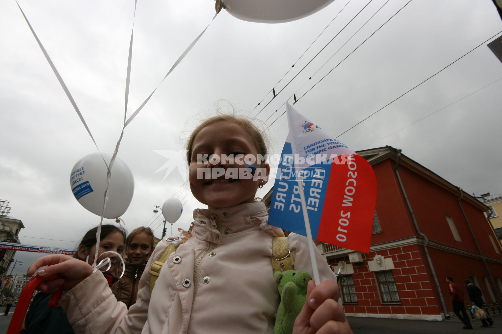 1 сентября 2007 года. День города. Девочка с триколором на щеке. Праздник.  Шарик. Флажок. Улица. Дом. Здание.