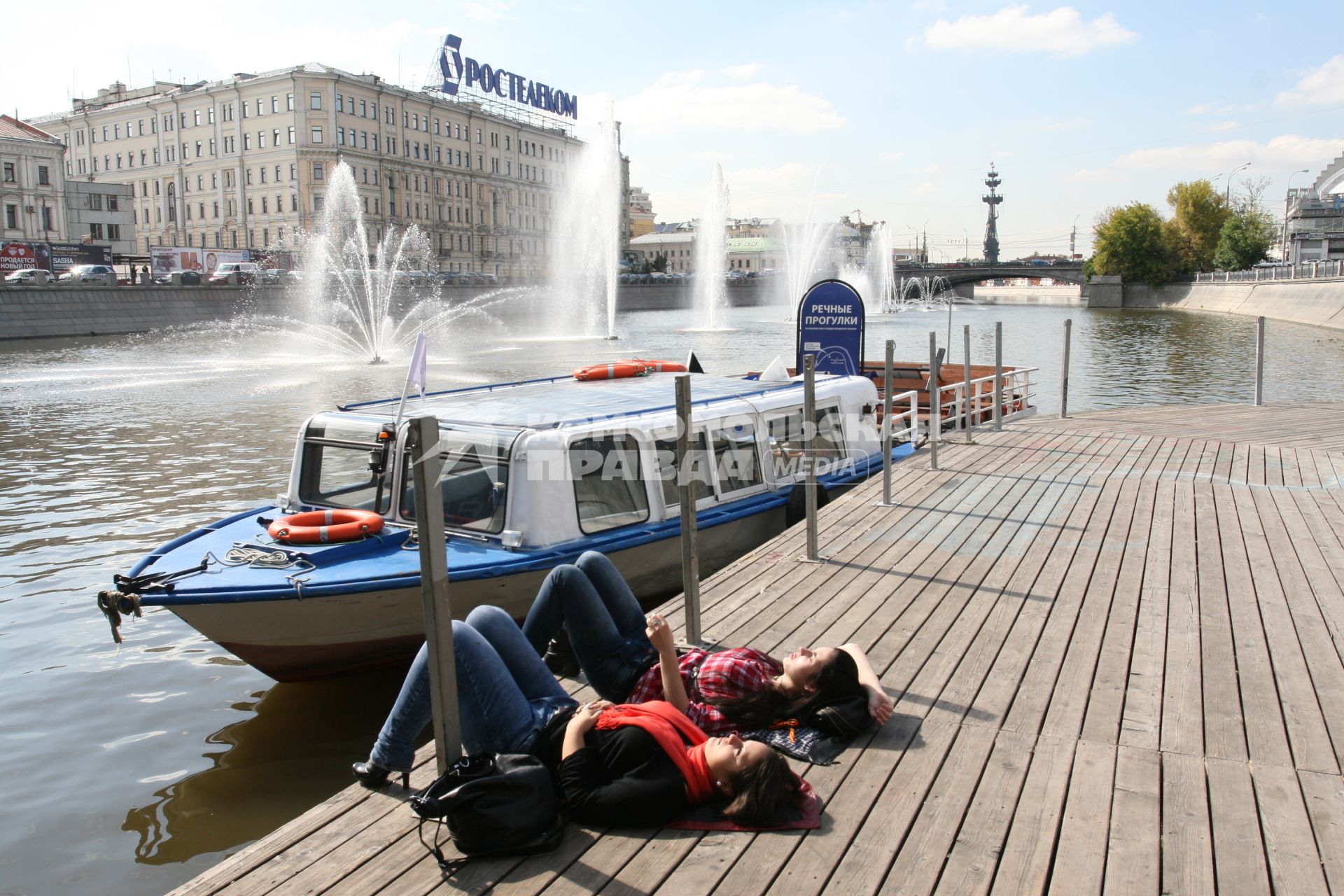 Прогулочные катера у причала под мостом. Погода. Солнце. Загар. Осень. Конец лета. Лето. Сезон. Отдых. Релакс. Девушки. Мечта.