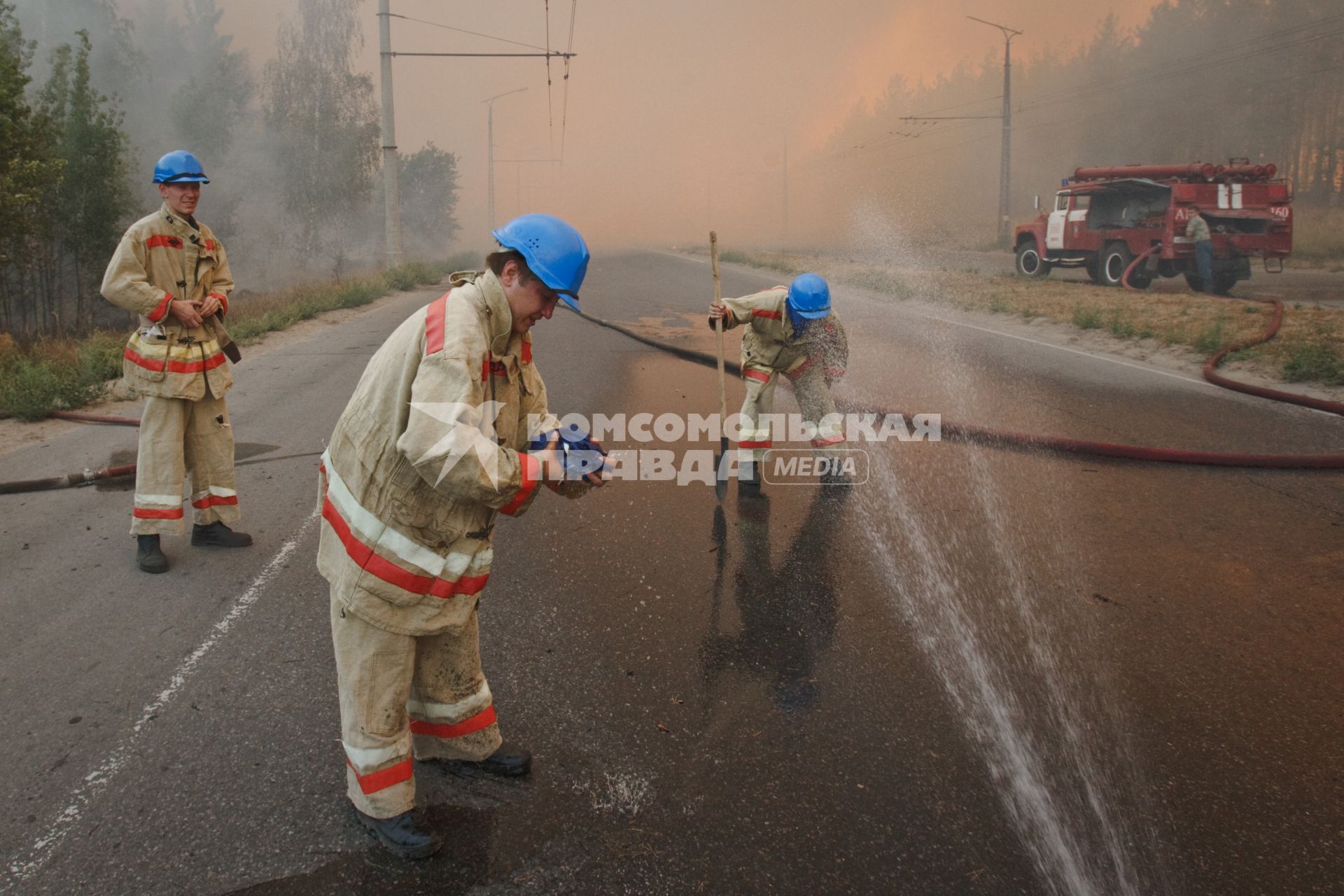 03.09.2010 Тольятти, Россия. Пожарные МЧС мочат водой одежду, чтобы спастись от перегрева на тушении лесного пожара.