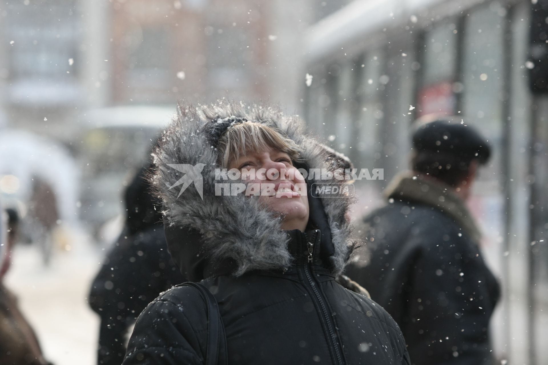 19.02.2010 Самара, Россия. Женщина смотрит вверх на идущий снег