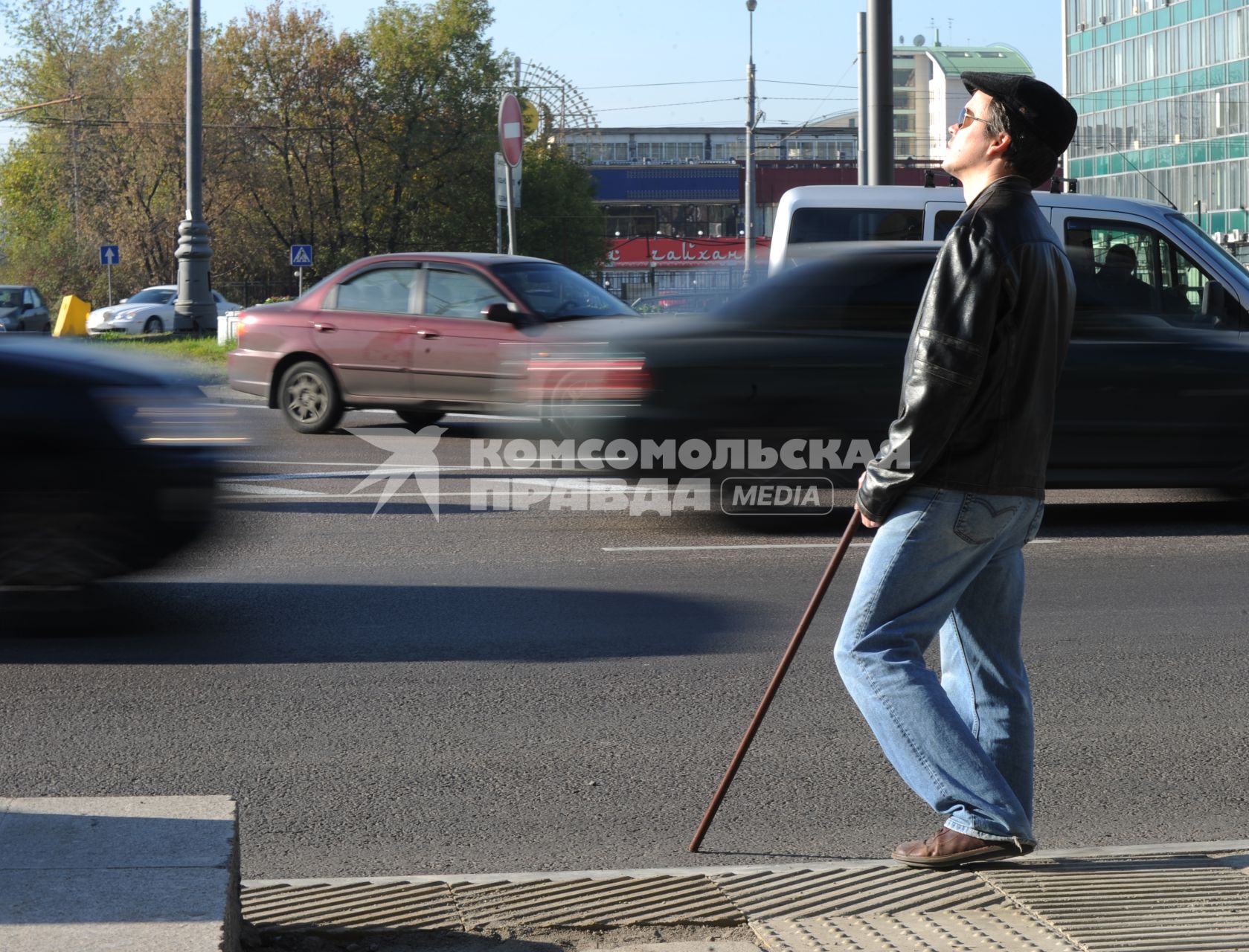 Слепой мужчина стоит у дороги