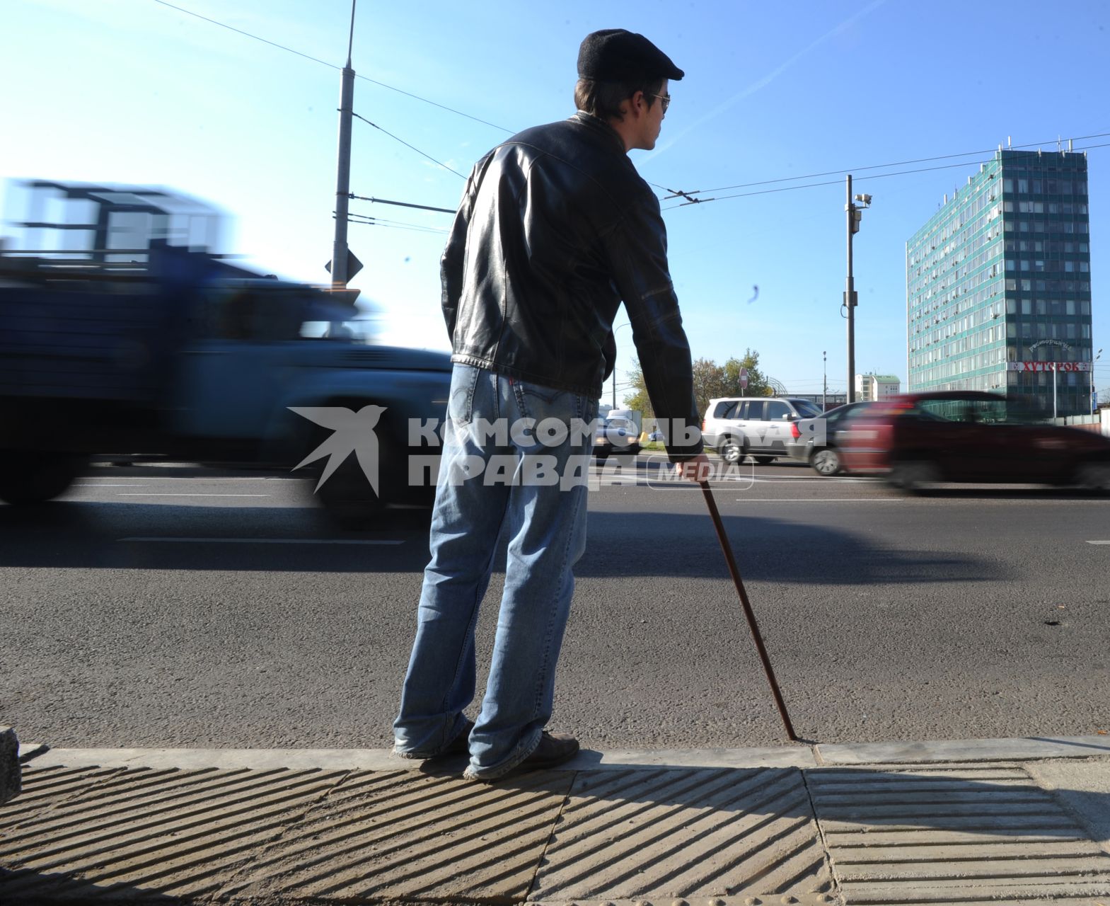 Слепой мужчина собирается переходить дорогу в неправильном месте.