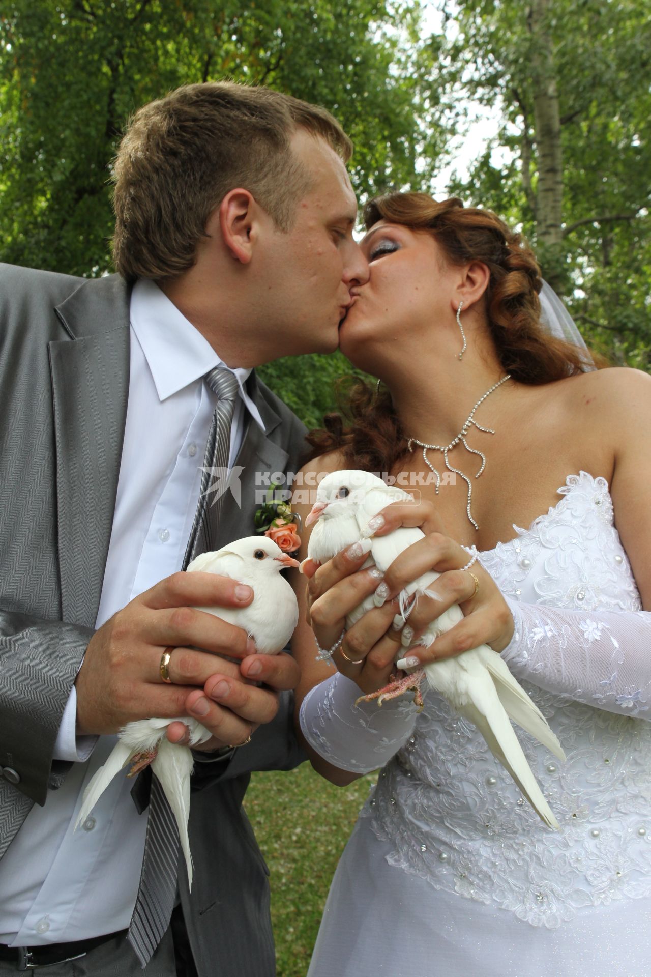 Дата: 26.06.2010, Время: 13:26. Молодая пара целуется держа в руках пару голубей.