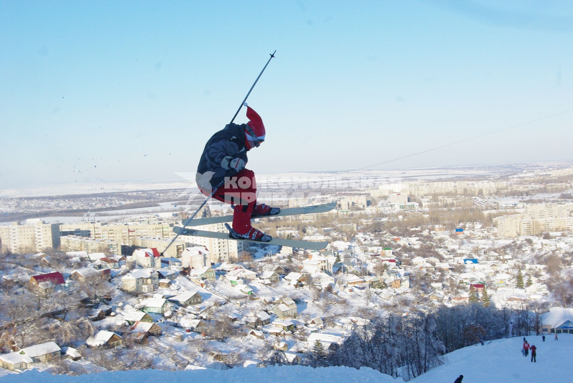 Лыжник в костюме деда мороза делает прыжок в воздухе, 9 марта 2010 года. Саратов. Зима, снег, зимние развлечения, отдых, горнолыжный курорт, лыжная база, сноубордист, лыжник, костюм лыжника, горнолыжная трасса, спорт, соревнование, дед мороз.