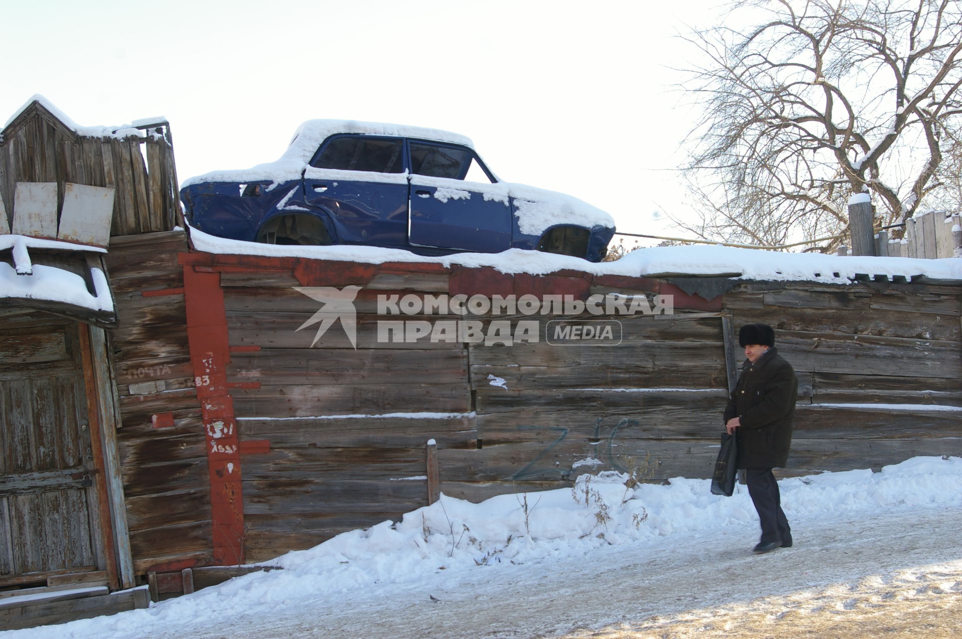 Старое авто стоит на крыше деревянного дома, Саратов, 12 января 2010 года. Снег, зима, старое авто, автомобиль, машина, утилизация, металлолом.